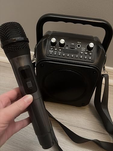 Close-up of a wireless microphone and portable karaoke machine in a home setting, emphasizing everyday use rather than display.