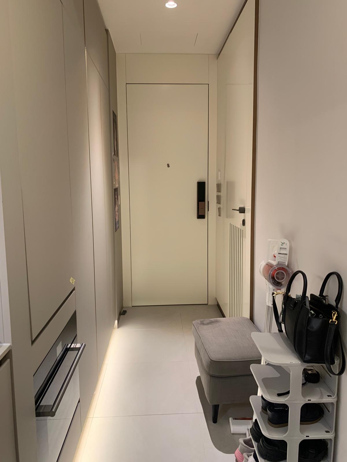 A compact apartment entryway in a client's home where storage and circulation are integrated into a narrow transitional space